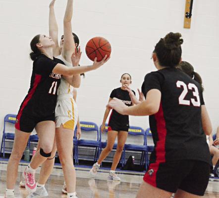 CANDIACE CLAYPOLE (left) attempts a reverse layup against Cameron as her Richmond teammates watch at the Husker Classic. SHAWN RONEY | Staff