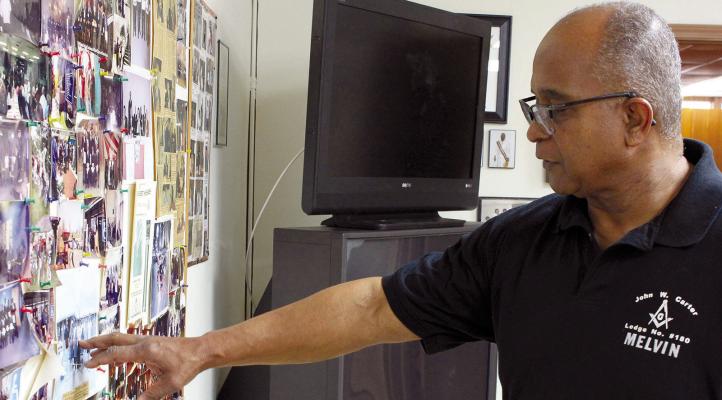 AS SENIOR WARTER Melvin Allen Jr. looks at old photos, he reminisces on quality community assurance. He points out pictures from past events when John W. Carter Lodge 180 members were more involved in the community. SOPHIA BALES | Staff