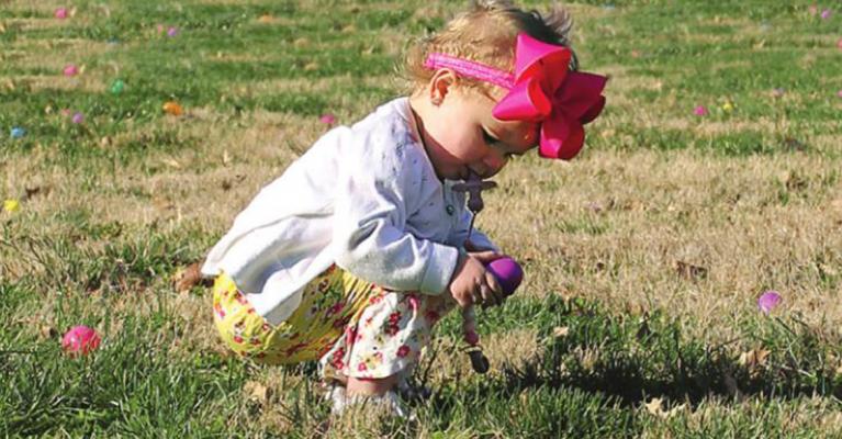 AT RICHMOND Parks and Recreation Department’s Community Easter Egg Hunt April 2 at Maurice Roberts Park, Kenlee Gilkey, 16 months, finds an egg. All hunters take the field under the protective eyes of Ray County Sheriff’s Office employees. In this case, Sgt. James Lawrence is near. J.C. VENTIMIGLIA | Staff