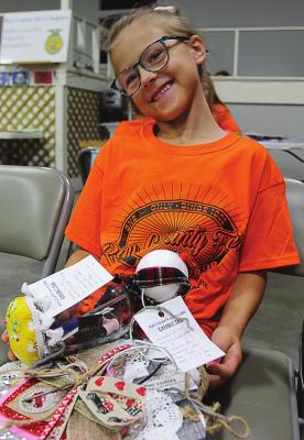 AT THE EAGLETON CENTER, which doubles as the Ray County Senior Center, McKynleigh Murray, 7, shows off her Ray County Fair exhibit. Murray is a 4-H Clover Kid with Dale-Patton 4-H Club.