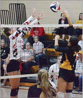 KAYLEE KING (left) attempts to block a tip shot by Orrick hitter Anela Fletcher Sept. 7 in the Orrick High School gym.