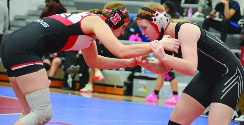 TAYLOR BAKER (left) of Richmond engages in hand fighting with Raytown South’s Madeline Murphy.