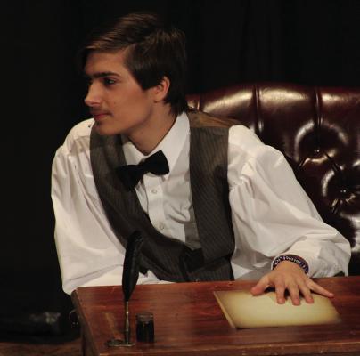 Timothy Vaughn portrays Laurie at his desk.