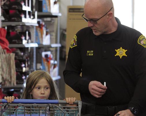 RAY COUNTY SHERIFF’S OFFICE Major Tom Noon (right) follows Kimber White to the toy aisle during the Shop with a Sheriff event. MIRANDA JAMISON | Staff