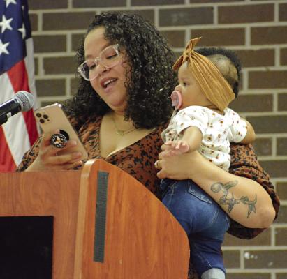 LASHONDA SCOTT juggles holding her daughter Zariah while reading her introduction for her father, Robert Robinson, as he’s inducted into the Richmond High School Athletic Hall of Fame June 8 at the high school. SHAWN RONEY | Staff
