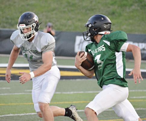 ZANDER STEVINSON, with the ball firmly tucked in his right arm, rushes as Braden Graves pursues him during the second half of the Missouri 8-Man Football Coaches Association All-Star Game June 24 in St. Joseph. SHAWN RONEY | Staff