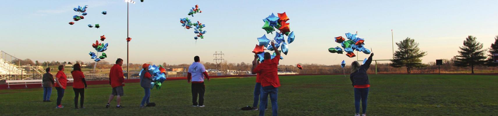 DOZENS OF BALLOONS fly from the middle of the Richmond High School football field in celebration of International Day for People with Disabilities.
