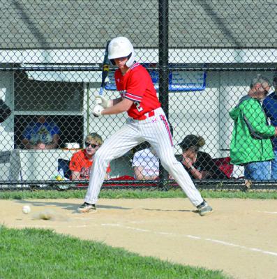 SOPHOMORE BRYER FARNAN takes a pitch low Tuesday at Fairground Park in Higginsville. SHAWN RONEY | Staff