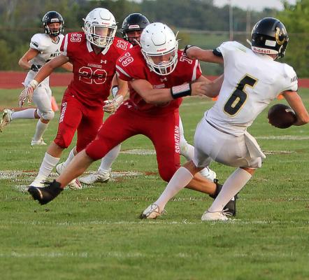 RICHMOND’S ZAIN WETTENGEL, a senior defensive lineman, forces Lathrop quarterback Mason Adwell to retreat.
