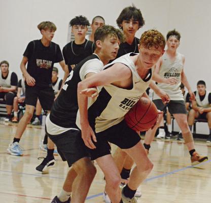 WITH THE BALL in his left hand, Hardin-Central’s Kaden McGinnis looks to dribble out of a crowd Monday at Lawson against Stewartsville/Osborn. SHAWN RONEY | Staff