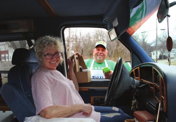 CURBSIDE SERVICE: Linda Pigg accepts a lunch serving from Kenny Goetz. J.C. VENTIMIGLIA | Staff