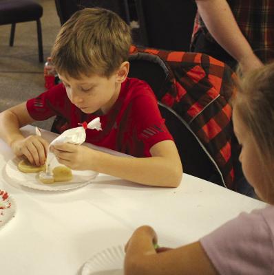 LUKE (LEFT) and Alice Covey frost cookies together with their family. SOPHIA BALES | Staff
