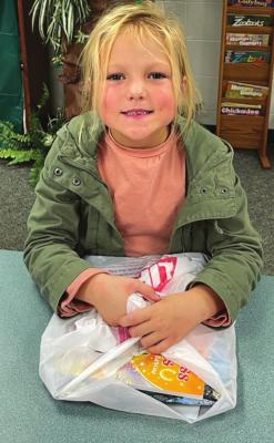 JOCIE WILLIAMS grabs a bag of books at the Dear Elementary book fair.
