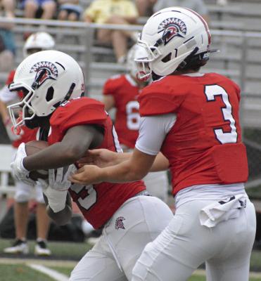 SOPHOMORE CARSON PERSELL (right) hands off to Savion Webb at a preseason jamboree before making his first varsity start at quarterback. SHAWN RONEY | Staff