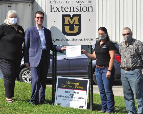 SPORTING SUNGLASSES, Troy Rust displays the certificate honoring his family farm, located near Hardin, as a Century Farm. The University of Missouri Extension and Missouri Farm Bureau provide the recognition. From left are Pam Bullock, MU Extension; Rust; Katie Neuner, MU Extension; and Jim Proffitt, Missouri Farm Bureau representative. SHAWN RONEY | Staff