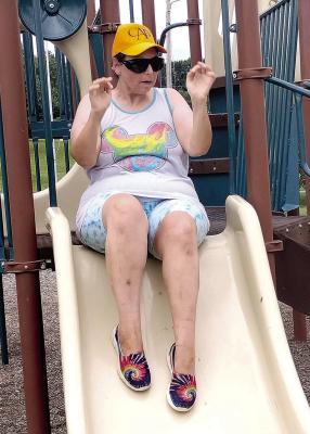 CONSTANCE ARNOLD takes a break from fishing for a turn on the slide.