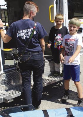 A RAY COUNTY AMBULANCE District employee shows ambulance highlights to Leo and Logan (right) Savage. SHARON DONAT | Staff