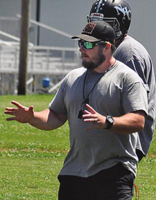 SPORTING HIS shades, ballcap and whistle, first-year varsity head coach Andrew Watson explains blocking assignments to his Aggies during Norborne Hardin-Central’s team camp for 8-man football. SHAWN RONEY | Staff