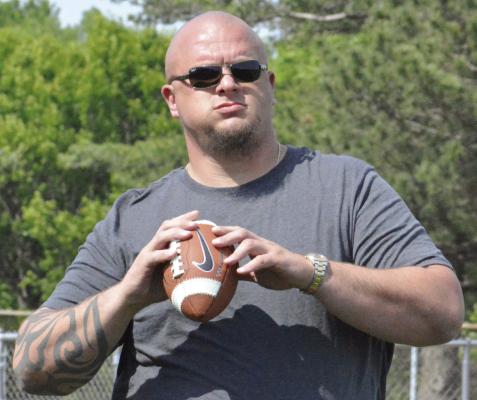 COLIN BROWN, a former pro football player and current United Methodist minister,sets to throw during warmups at Future Spartan Youth Football Camp. SHAWN RONEY | Staff
