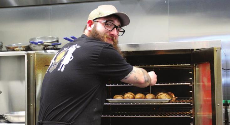 OPENING THE OVEN in Branded Steakhouse’s spacious kitchen, Jacob O’Dell tends potatoes baking for the lunch crowd.