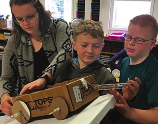 MEASURING FORCE: Julie Kreikemeier shows students in Clarkson, Nebraska, how to measure force in newtons.