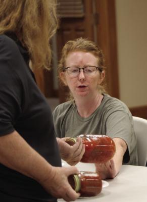 RACHELL BEACH examines jars of salsa during a canning demonstration. SHARON DONAT | Staff