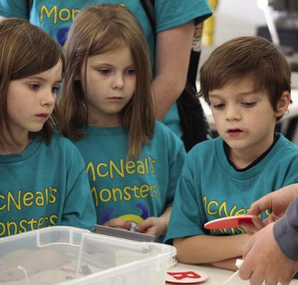 MACI HOUSER (from left), Zarya Clemens and Zeke Curtis learn to make coasters.