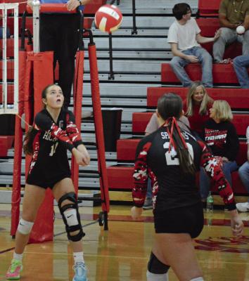 GENEVIEVE DIDIER (left) has her hands set for a bump pass as teammate Avory Oliphant watches during Richmond’s Senior Night match with Lexington. SHAWN RONEY | Staff