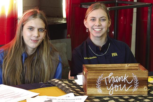 ELLISON (LEFT) AND Emerson Rennison welcome community members to the FFA breakfast.