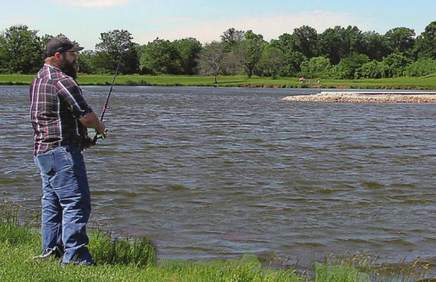 ON THE EAST SIDE of Ray County Lake, David Wratt, Richmond, fishes. In the background is evidence of work to improve lake facilities, which will include improved parking and new restroom facilities.