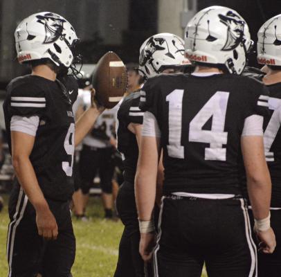 NORBORNE HARDIN-CENTRAL quarterback Brody Fifer (left) looks to hand the ball to an official after the Aggies take a knee to run out the clock on their homecoming win over Orrick. SHAWN RONEY | Staff