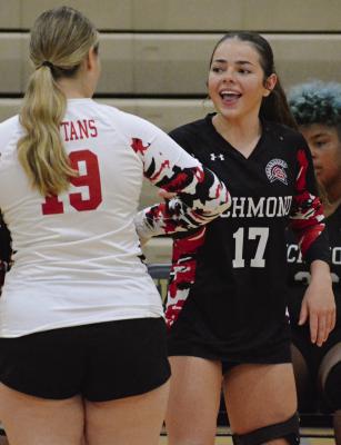 GENEVIEVE DIDIER (right) is greeted by Kaitlyn Marrant as she is introduced before Richmond’s district volleyball match with Oak Grove. SHAWN RONEY | Staff