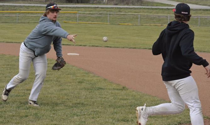 JUNIOR JACOB LIEBERKNECHT (left) flips the ball toward first base after fielding a bunt.