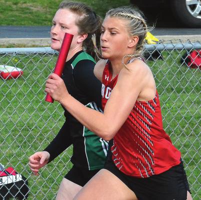 WITH THE BATON held high and the wind befriending her, Richmond sophomore Kaylee Pugh buzzes down the front straightaway as she runs the second leg of the girls 400-meter relay April 22 at Excelsior Springs. SHAWN RONEY | Staff