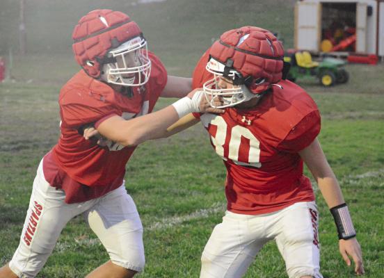 TRISTIN McCOY (left) blocks teammate Colton Hewlett on Richmond’s practice field as the Spartans prep to face Cameron Friday night in district play. SHAWN RONEY | Staff