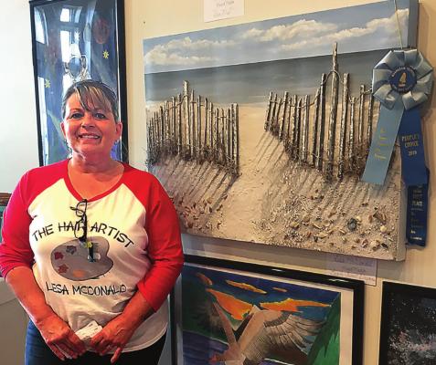 THE 2019 People’s Choice award winner during the Ray County Community Arts Association’s Annual Fine Arts and Photography Show, Lesa McDonald, shows off her painting.