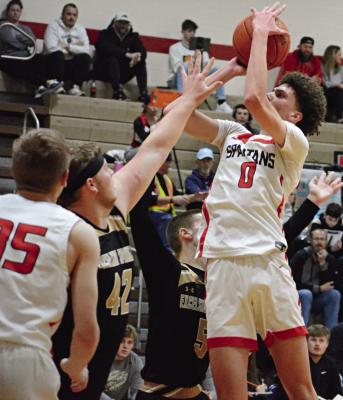 RICHMOND JUNIOR Gabe Johnson shoots over the outstretched left hand of Excelsior Springs junior Cooper Bishop Monday night in Winter Classic action at Richmond Middle School. SHAWN RONEY | Staff