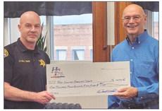 HERO FUND USA CEO Darrell Smith (right) presents Ray County Sheriff’s Office Lieutenant Colonel Tom Noon with funding toward the purchase of a new mobile radio. MIRANDA JAMISON | Staff