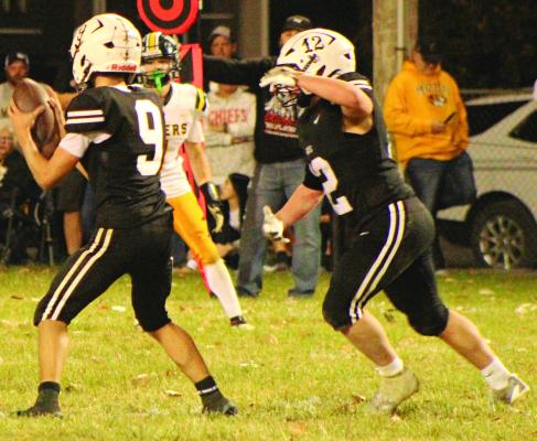 QUARTERBACK BRODY FIFER (left) reads the defense as Jagger McNelly prepares for a possible handoff during Norborne Hardin-Central’s district title meeting with Wellington-Napoleon. SHARON DONAT | Staff