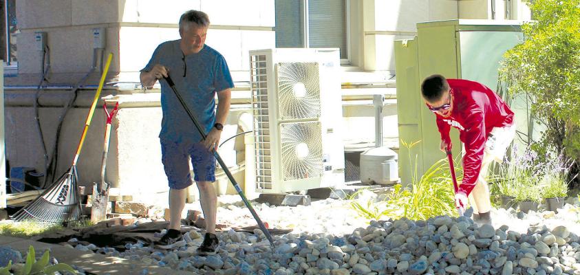 MIKE CHOWNING (left) and son, Caleb, distribute rocks around the county courthouse. SHARON DONAT | Staff