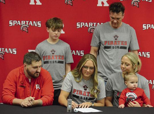 RICHMOND SENIOR Isabella Smith signs her letter of intent to play women’s golf at North Central Missouri College, surrounded by members of her family. Also pictured are (from left), front row, Jordan Smith, Nora Boguskie and Stephanie Williams-Boguskie; back row, Brady Boguskie and Jeff Boguskie. SHAWN RONEY | Staff