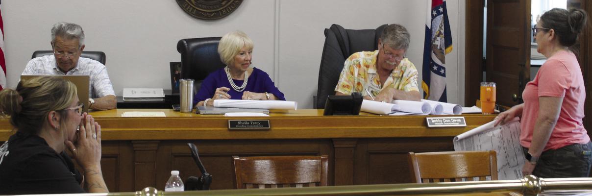 PLANNING AND ZONING Administrator Stacy Wolfe (right) presents subdivision plats to commissioners for review and signatures. MIRANDA JAMISON | Staff