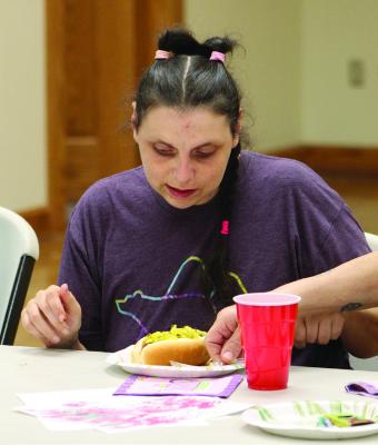 CONSTANCE ARNOLD samples a hot dog topped with zucchini relish. SHARON DONAT | Staff