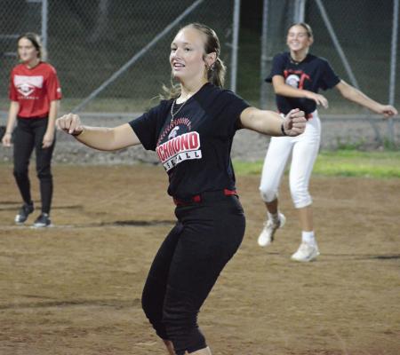 KYNLEE LOPEZ (center) helps to lead the Richmond varsity softball team in exercises shortly after midnight Monday in the ballclub’s first practice of the fall sports season. SHAWN RONEY | Staff