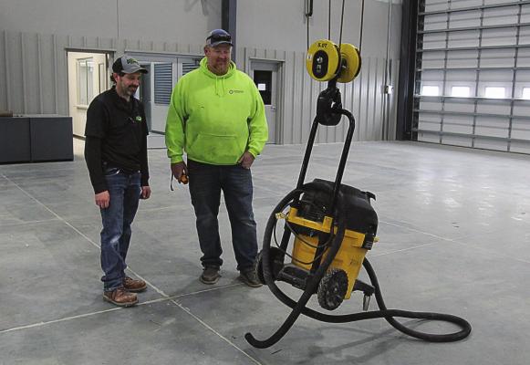 INSIDE the new Ag-Power building that is almost ready to open at Highways 210 and 10, parts manager Curt Calvert and Septagon’s Dave White demonstrate how easily the overhead crane operates. J.C. VENTIMIGLIA | Staff