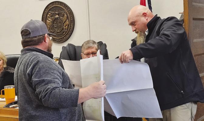 GREEN HILLS COMMUNICATIONS plant manager Chris Shoe (right) and Commissioner Bobby Don Davis review a map detailing copper infrastructure upgrades needed to support increasing demand for fiber-optic internet. MIRANDA JAMISON | Staff
