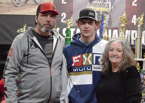 XANDYN TAYLOR (center) of Richmond enjoys the spoils of his victories as a motocross racer during a party thrown by his parents (from left), Jamie and Tamara Taylor. Look for additional coverage of the Taylors’ celebration March 7. SHAWN RONEY | Staff