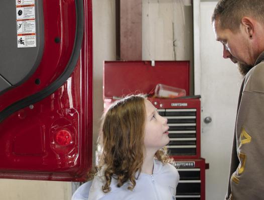 RUBY MARSHALL and her dad explore fire trucks during event festivities. MIRANDA JAMISON | Staff