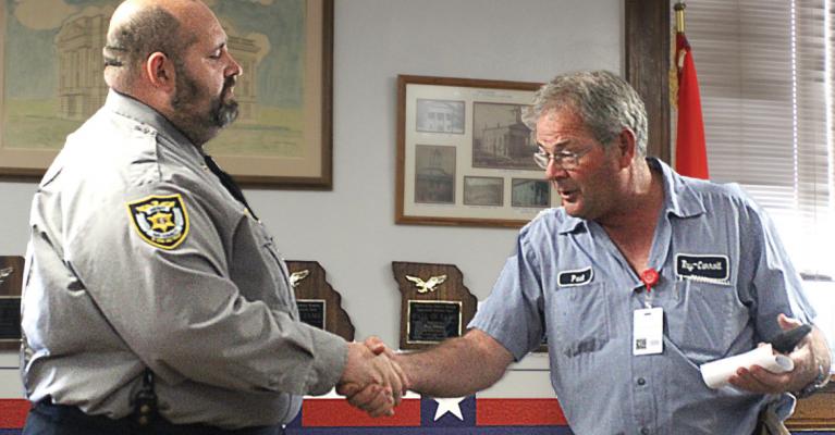 THEY AGREE to disagree, with Sheriff Scott Childers shaking hands with 911 Board President Paul Harris at the end of the County Commission meeting. Childers wants the public to vote to give his office 40% of the tax money now going to 911 so that he can build a county justice center and increase staff.