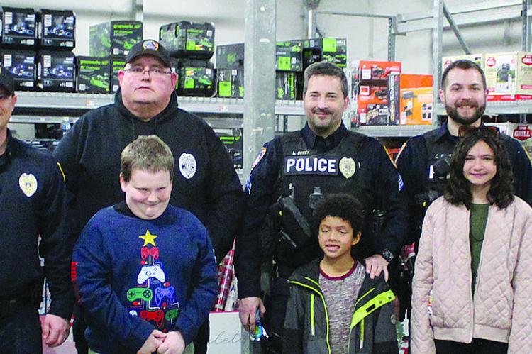 RICHMOND POLICE officers and the children they shopped with for the Shop with a Cop progrma stop for a group photo.